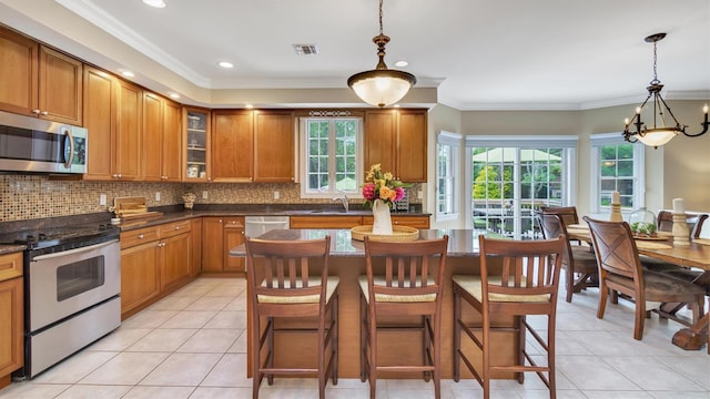 1260 Water Ter, Southold, NY 11971 - kitchen with stainless steel appliances, healthy amount of natural light, light tile patterned floors, ornamental molding, and recessed lighting
