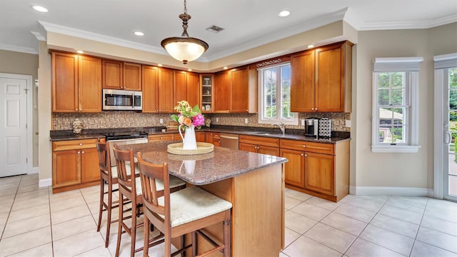 1260 Water Ter, Southold, NY 11971 - kitchen featuring stainless steel appliances, brown cabinets, light tile patterned flooring, decorative backsplash, and ornamental molding