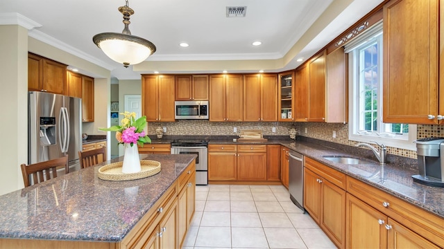 1260 Water Ter, Southold, NY 11971 - kitchen featuring appliances with stainless steel finishes, a sink, brown cabinetry, backsplash, and crown molding