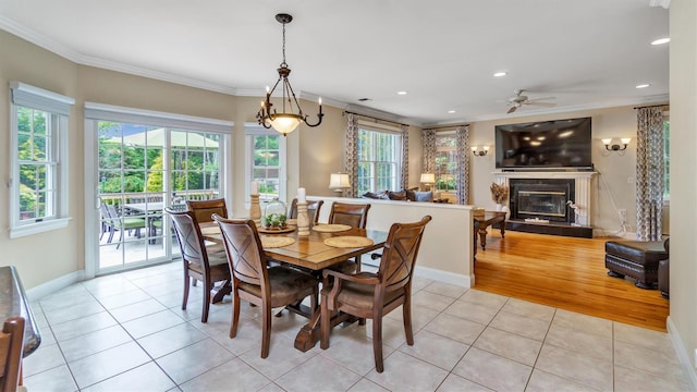 1260 Water Ter, Southold, NY 11971 - dining space featuring ornamental molding, light tile patterned floors, a glass covered fireplace, ceiling fan, and baseboards