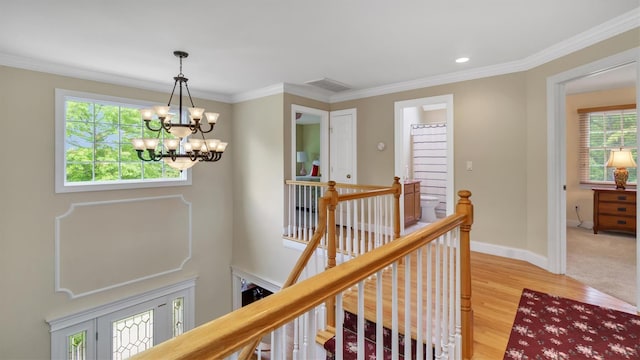 1260 Water Ter, Southold, NY 11971 - hallway featuring an upstairs landing, a chandelier, healthy amount of natural light, light wood-style flooring, and crown molding