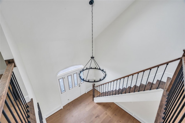205 Blueberry Ln, Hicksville, NY 11801 - staircase featuring wood finished floors, a chandelier, a towering ceiling, and baseboards