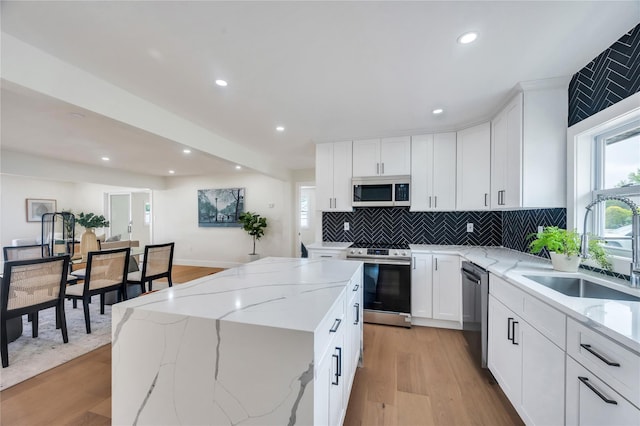 205 Blueberry Ln, Hicksville, NY 11801 - kitchen featuring appliances with stainless steel finishes, a sink, light wood finished floors, backsplash, and recessed lighting