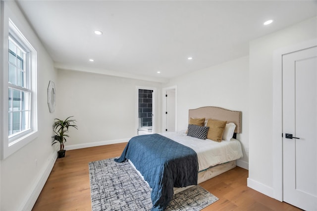 205 Blueberry Ln, Hicksville, NY 11801 - bedroom with multiple windows, wood finished floors, baseboards, recessed lighting, and a baseboard heating unit