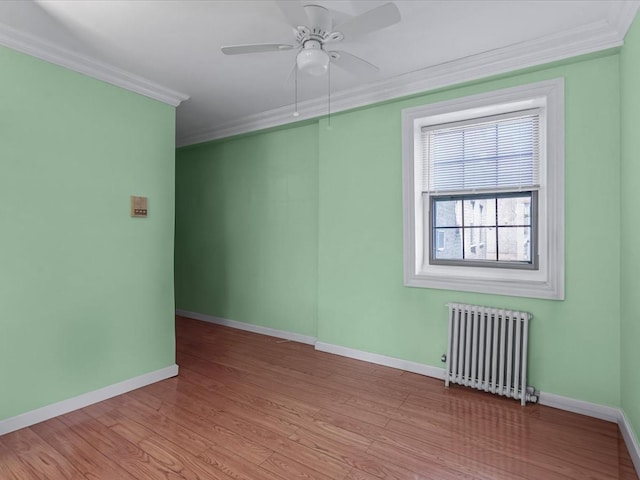 147-11 79th Ave Unit 1N, Flushing, NY 11367 - spare room featuring radiator heating unit, crown molding, baseboards, a ceiling fan, and wood finished floors