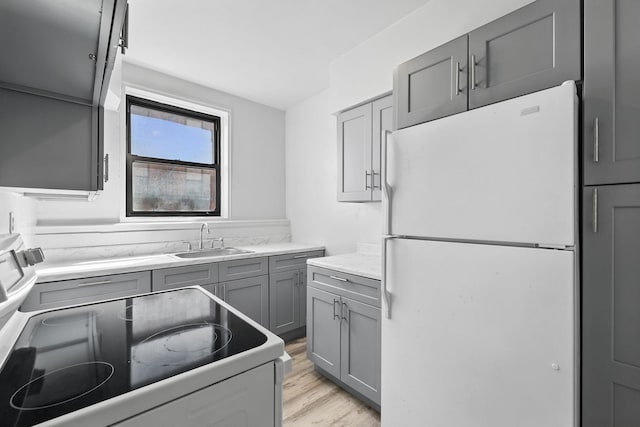 10 N Broadway Unit 3H, White Plains, NY 10601 - kitchen featuring white appliances, gray cabinets, a sink, and light wood-type flooring