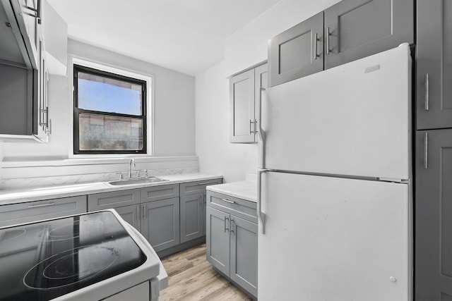 10 N Broadway Unit 3H, White Plains, NY 10601 - kitchen featuring freestanding refrigerator, gray cabinets, stove, a sink, and light wood-type flooring