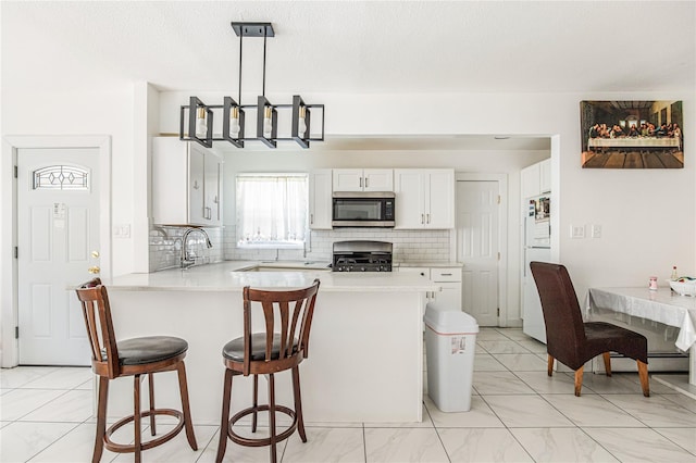 45 Cragmere Rd, Airmont, NY 10901 - kitchen featuring stainless steel microwave, range, a peninsula, and light countertops