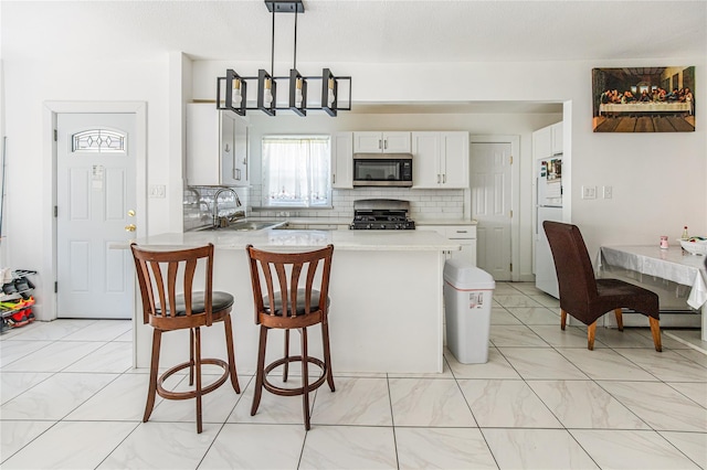 45 Cragmere Rd, Airmont, NY 10901 - kitchen featuring stainless steel microwave, gas range, a sink, a peninsula, and tasteful backsplash