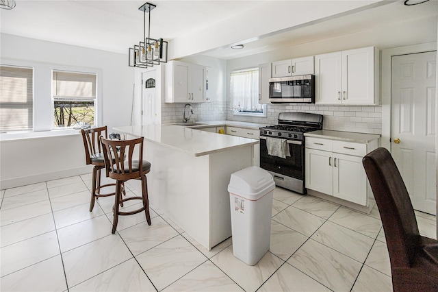 45 Cragmere Rd, Airmont, NY 10901 - kitchen with appliances with stainless steel finishes, a peninsula, a sink, a kitchen bar, and white cabinets
