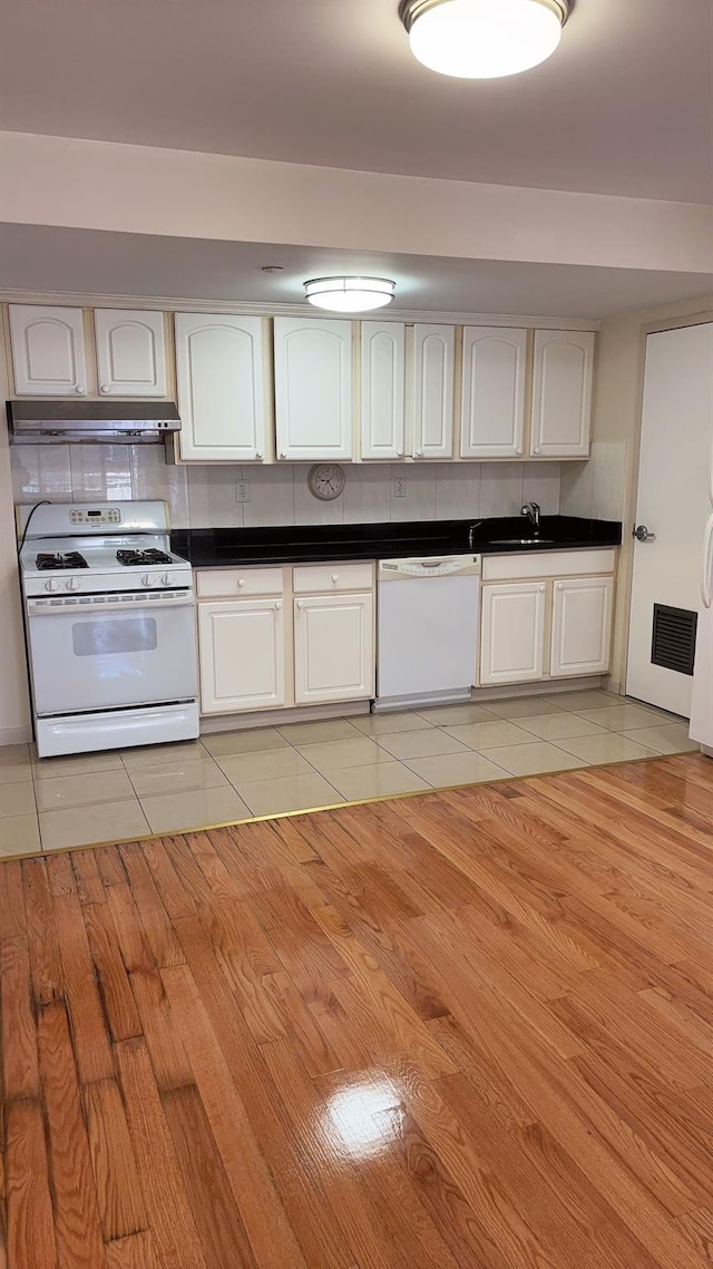 43-17 Union St Unit 6G, Flushing, NY 11355 - kitchen with white appliances, under cabinet range hood, light tile patterned floors, dark countertops, and a sink