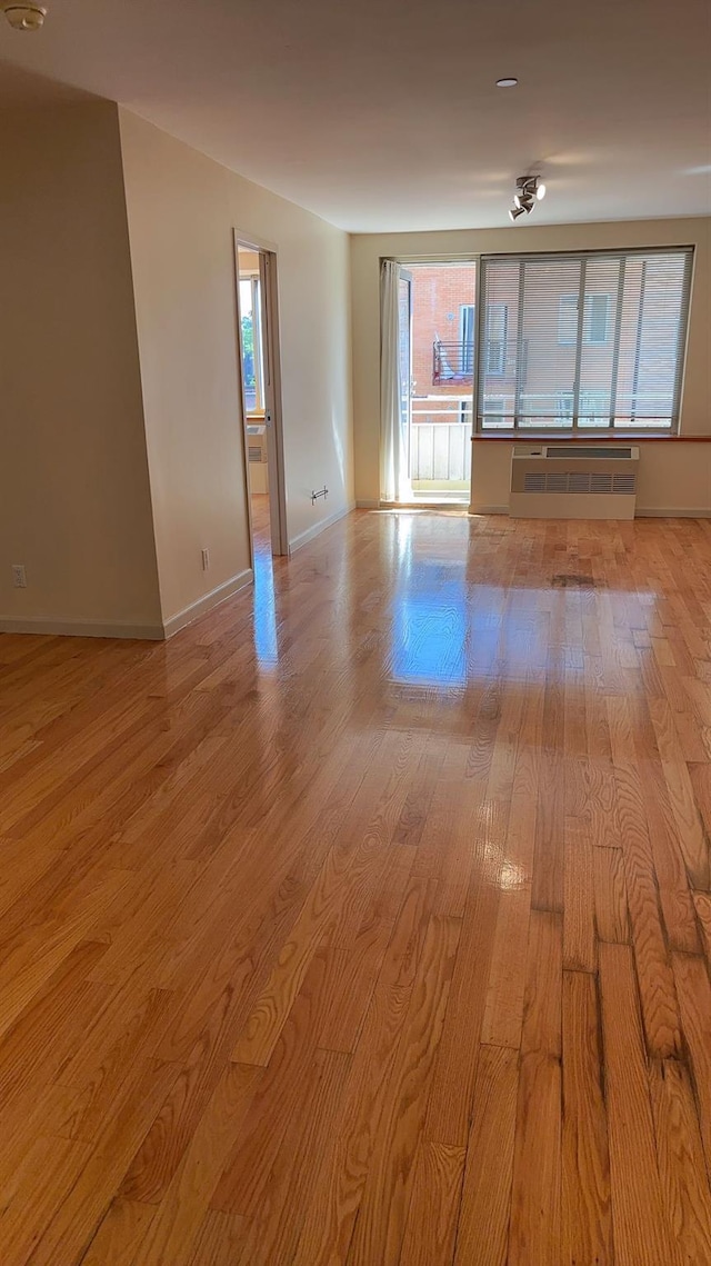 43-17 Union St Unit 6G, Flushing, NY 11355 - empty room featuring healthy amount of natural light, light wood-style floors, a wall mounted air conditioner, and baseboards