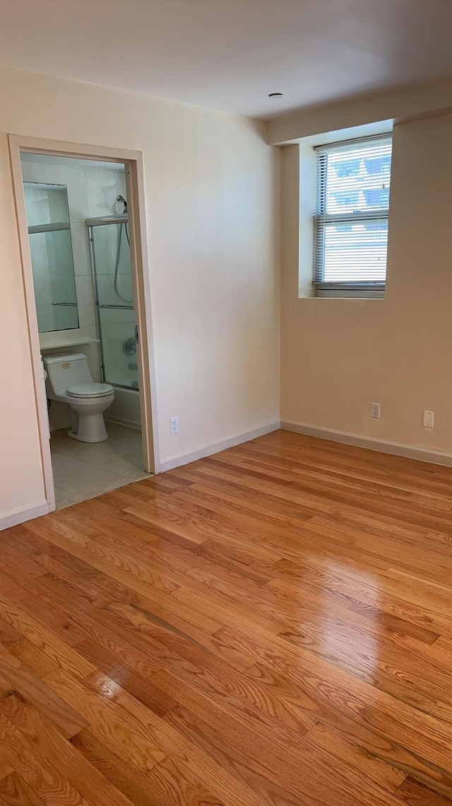 43-17 Union St Unit 6G, Flushing, NY 11355 - unfurnished bedroom with wood finished floors, baseboards, and ensuite bathroom