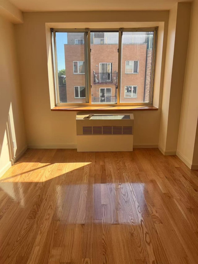 43-17 Union St Unit 6G, Flushing, NY 11355 - empty room with wood finished floors, baseboards, and radiator heating unit