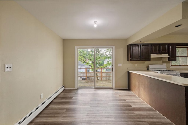 12 Gillis Ave, Nyack, NY 10960 - kitchen with gas range, a baseboard radiator, under cabinet range hood, light countertops, and wood finished floors