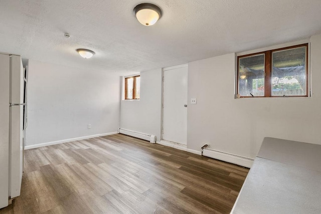 12 Gillis Ave, Nyack, NY 10960 - empty room with a baseboard heating unit, a textured ceiling, and wood finished floors