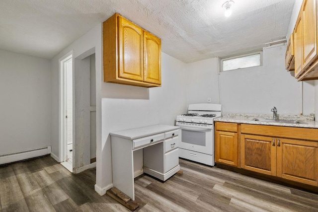12 Gillis Ave, Nyack, NY 10960 - kitchen with white gas range, wood finished floors, a baseboard radiator, and brown cabinets