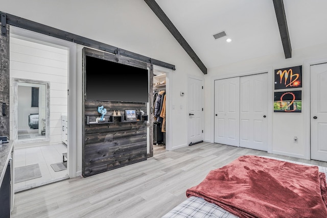 8 Hamilton Pl, Lake Grove, NY 11755 - bedroom featuring light wood finished floors, two closets, connected bathroom, a barn door, and baseboards