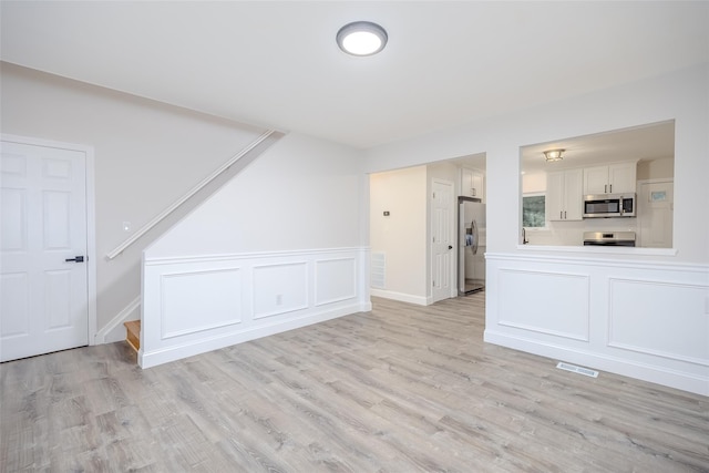 59 Burney Blvd, Mastic, NY 11950 - unfurnished living room with light wood-style floors and stairs