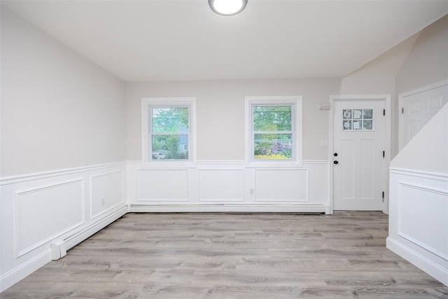 59 Burney Blvd, Mastic, NY 11950 - unfurnished dining area featuring a wainscoted wall, light wood-style floors, and a decorative wall