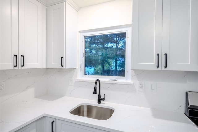 59 Burney Blvd, Mastic, NY 11950 - kitchen featuring a sink, decorative backsplash, white cabinets, and light stone countertops