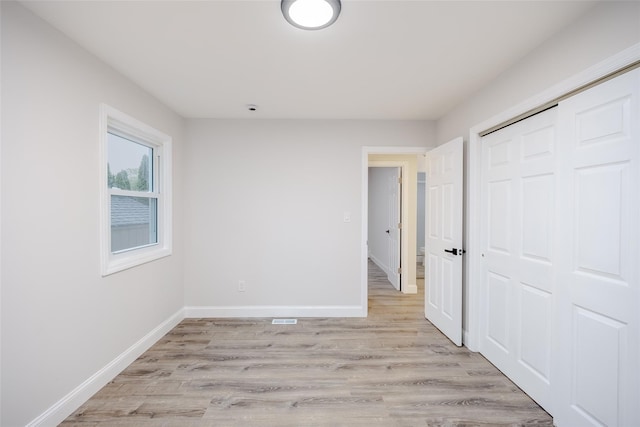 59 Burney Blvd, Mastic, NY 11950 - unfurnished bedroom with light wood-style floors, baseboards, and a closet