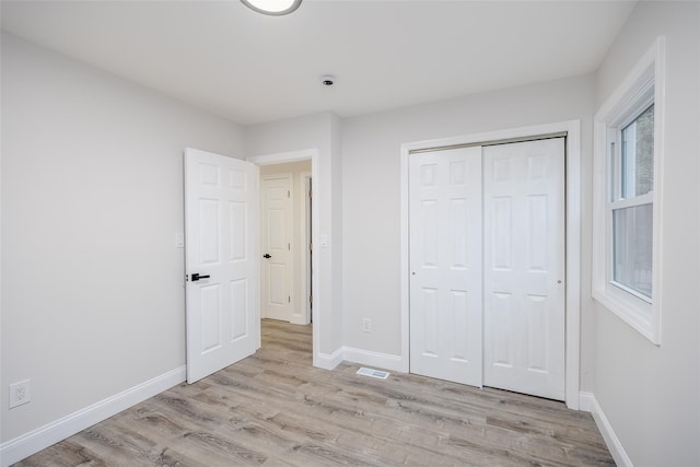59 Burney Blvd, Mastic, NY 11950 - unfurnished bedroom with light wood-style floors, baseboards, and a closet