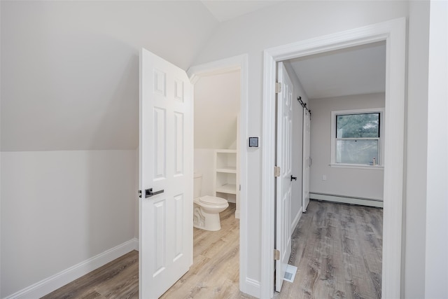 59 Burney Blvd, Mastic, NY 11950 - bathroom with baseboard heating, vaulted ceiling, toilet, wood finished floors, and baseboards