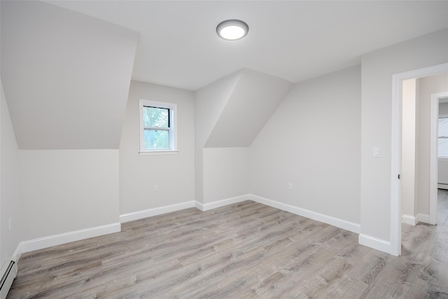 59 Burney Blvd, Mastic, NY 11950 - additional living space with light wood-style floors, baseboards, a baseboard radiator, and lofted ceiling
