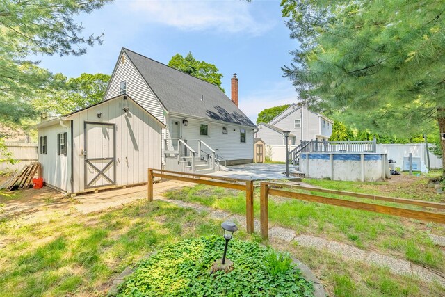 59 Burney Blvd, Mastic, NY 11950 - back of property featuring a shed, a chimney, and roof with shingles