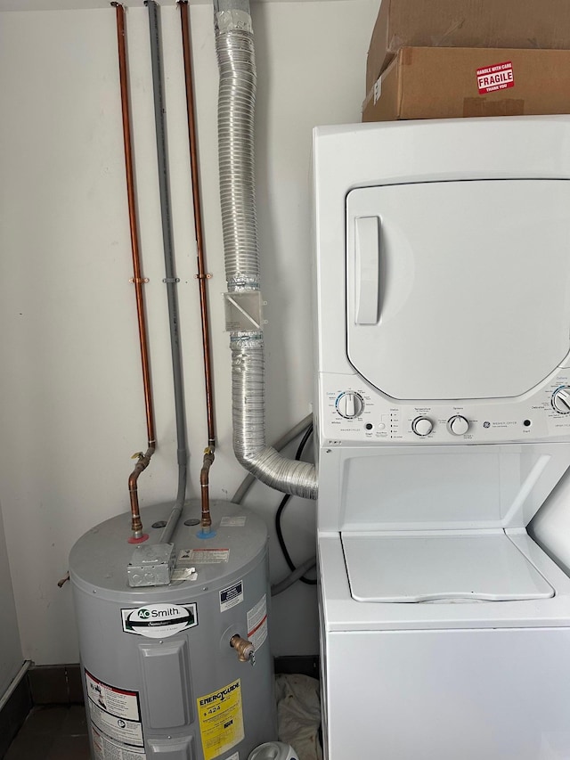 1626 Mogul Dr Unit 1626, Mohegan Lake, NY 10547 - washroom with estacked washer and dryer, water heater, and baseboards