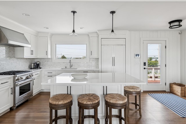 355 Dune Rd, Westhampton Beach, NY 11978 - kitchen featuring high end stove, a kitchen bar, healthy amount of natural light, and dark wood-type flooring