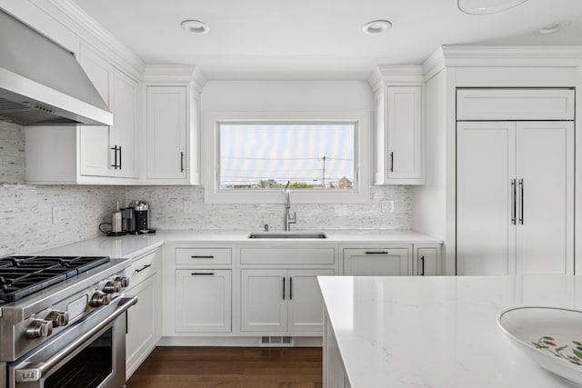 355 Dune Rd, Westhampton Beach, NY 11978 - kitchen with wall chimney range hood, high end appliances, white cabinets, decorative backsplash, and dark wood-type flooring