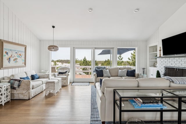 355 Dune Rd, Westhampton Beach, NY 11978 - living area featuring wood finished floors, built in features, a brick fireplace, and wooden walls
