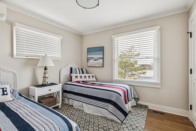 355 Dune Rd, Westhampton Beach, NY 11978 - bedroom featuring multiple windows, ornamental molding, wood finished floors, and a wall mounted air conditioner