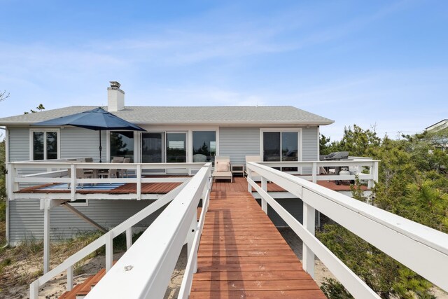 355 Dune Rd, Westhampton Beach, NY 11978 - rear view of house with a chimney, a shingled roof, and a deck