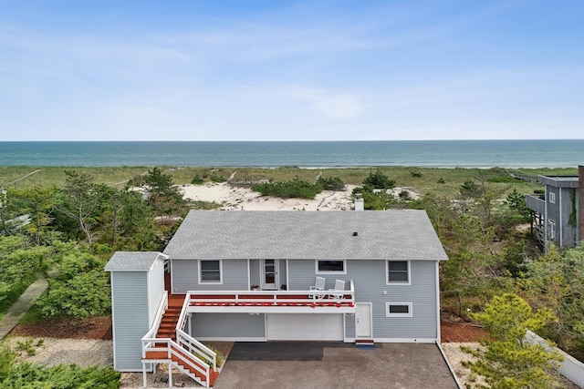 355 Dune Rd, Westhampton Beach, NY 11978 - view of front of property with an attached garage, roof with shingles, a water view, asphalt driveway, and stairs