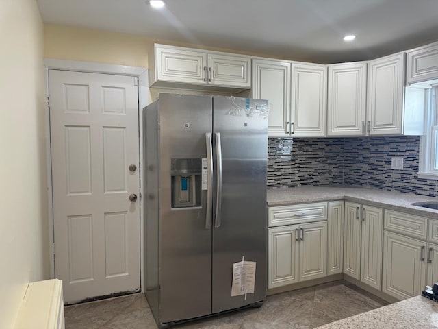 110 Terrace Ave, Elmont, NY 11003 - kitchen with stainless steel fridge with ice dispenser, light countertops, decorative backsplash, white cabinets, and recessed lighting