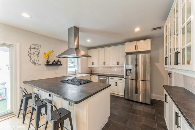 32 Henderson Ave, Port Washington, NY 11050 - kitchen featuring appliances with stainless steel finishes, island range hood, dark countertops, tasteful backsplash, and recessed lighting