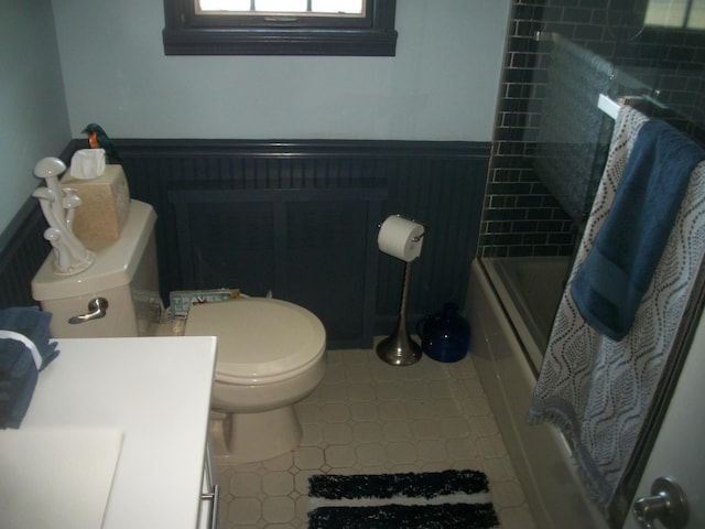 2713 Fox Rd, Baldwin, NY 11510 - bathroom with tile patterned flooring, a wainscoted wall, shower / bath combo, vanity, and toilet