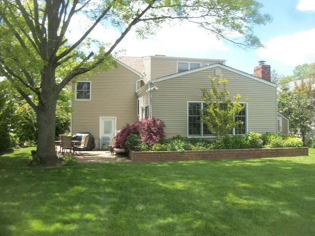 2713 Fox Rd, Baldwin, NY 11510 - rear view of house with a patio area, a yard, and a chimney