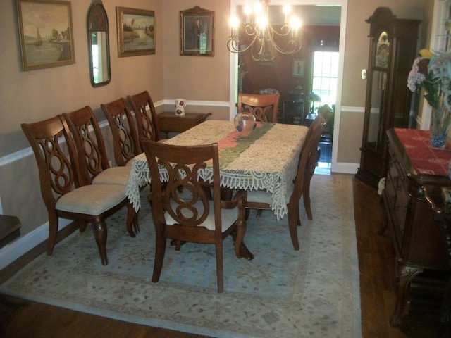 2713 Fox Rd, Baldwin, NY 11510 - dining room with a chandelier, baseboards, and wood finished floors