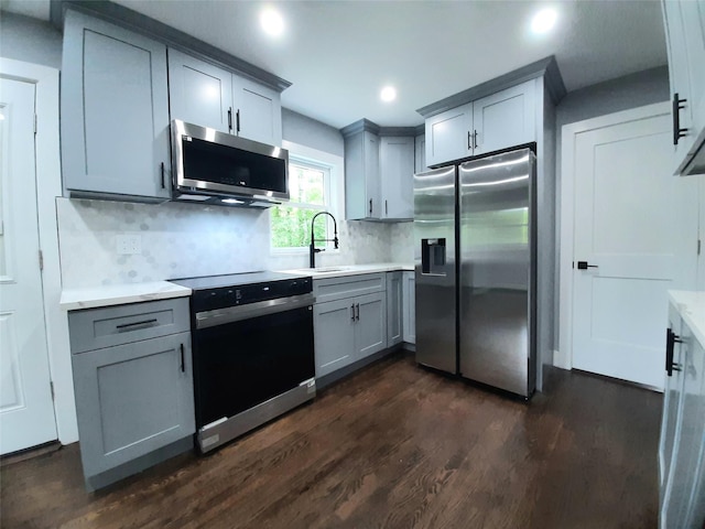 495 Stanton Ter, Poughkeepsie, NY 12603 - kitchen featuring stainless steel appliances, gray cabinets, a sink, dark wood finished floors, and tasteful backsplash