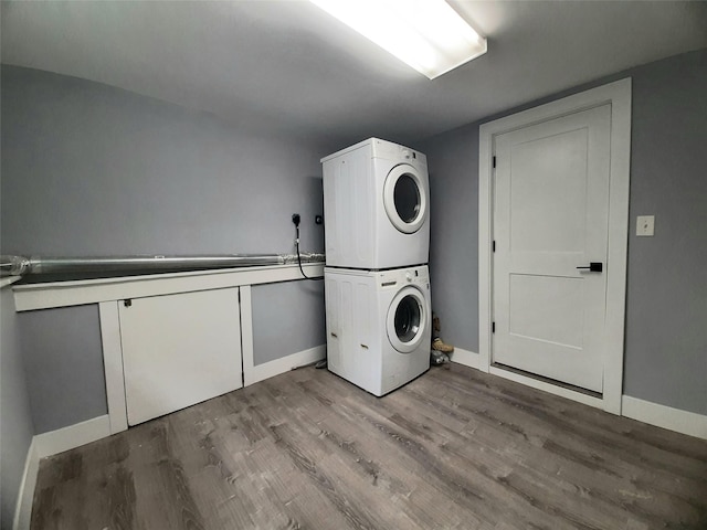 495 Stanton Ter, Poughkeepsie, NY 12603 - laundry room with stacked washer and clothes dryer, wood finished floors, and baseboards