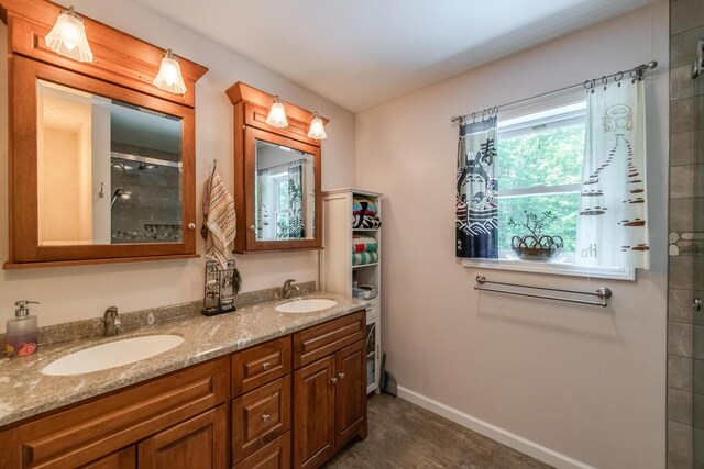 36 Valkill Dr, Poughkeepsie, NY 12601 - full bath with double vanity, a tile shower, wood finished floors, and baseboards