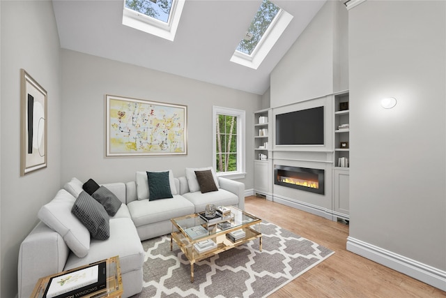 3 Hageman Ct, Katonah, NY 10536 - living room featuring a skylight, a glass covered fireplace, built in shelves, light wood-type flooring, and high vaulted ceiling
