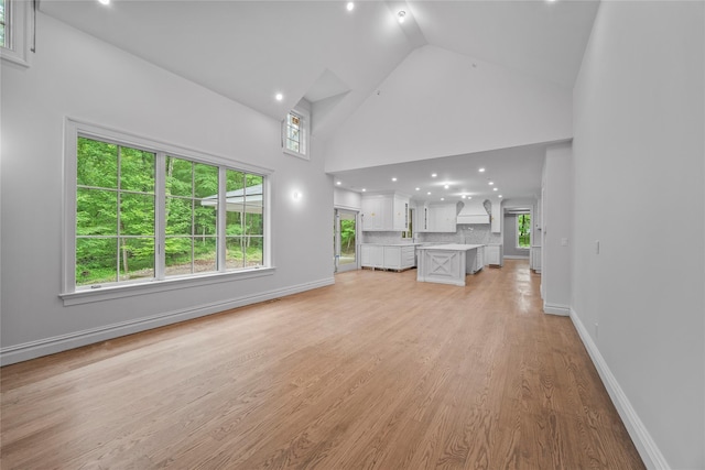 3 Hageman Ct, Katonah, NY 10536 - unfurnished living room featuring high vaulted ceiling, light wood-style floors, and baseboards