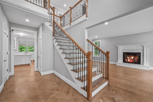 3 Hageman Ct, Katonah, NY 10536 - stairway featuring baseboards, crown molding, a fireplace, recessed lighting, and a high ceiling