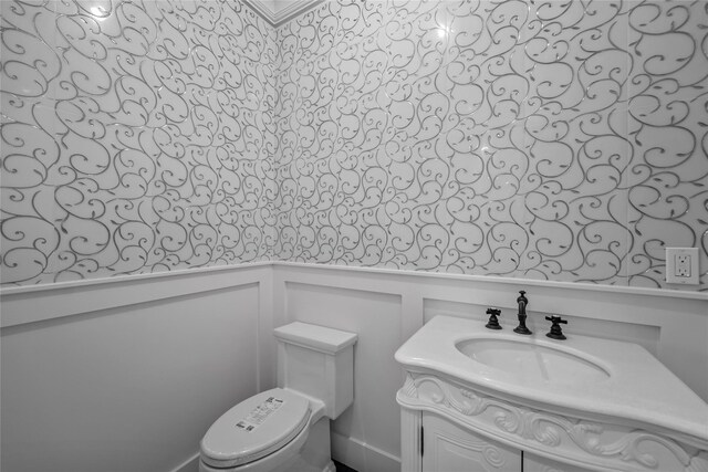 3 Hageman Ct, Katonah, NY 10536 - half bathroom with toilet, vanity, a wainscoted wall, and a decorative wall