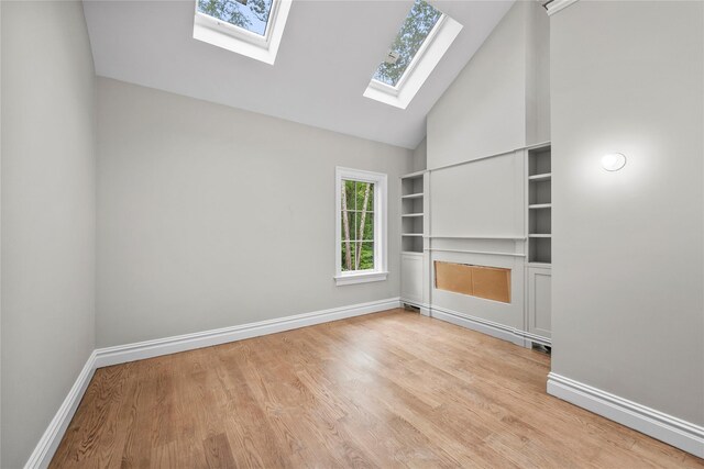 3 Hageman Ct, Katonah, NY 10536 - unfurnished bedroom featuring a skylight, baseboards, high vaulted ceiling, and wood finished floors